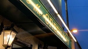 Eine Neonreklame heißt Besucher im Pub Green Man willkommen.