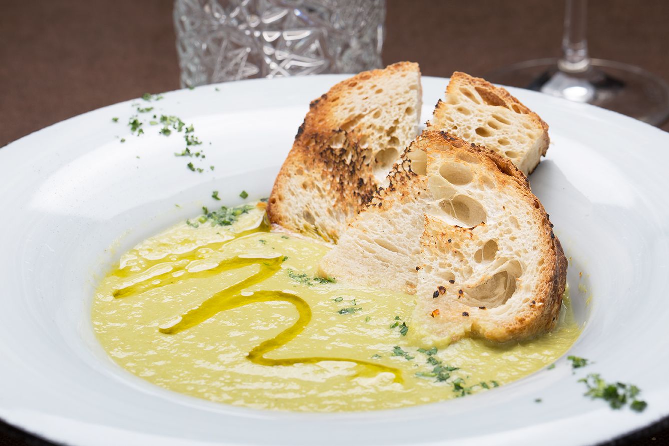 Un plato de sopa cremosa y pan tostado.
