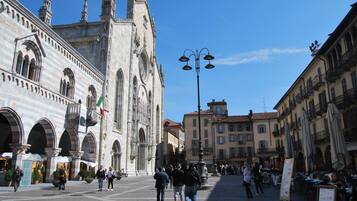Une place historique, dominée par une imposante cathédrale, avec des rues pavées et des espaces aménagés pour s’asseoir à l’extérieur.