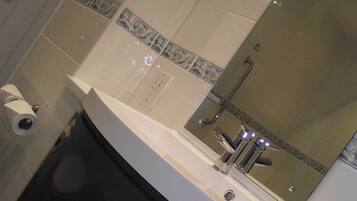 Un baño con lavamanos blanco, un espejo y un inodoro.