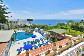 A resort with a pool, sun loungers, and a view of the sea. - Hotel Saint Raphael (Barano d'Ischia)