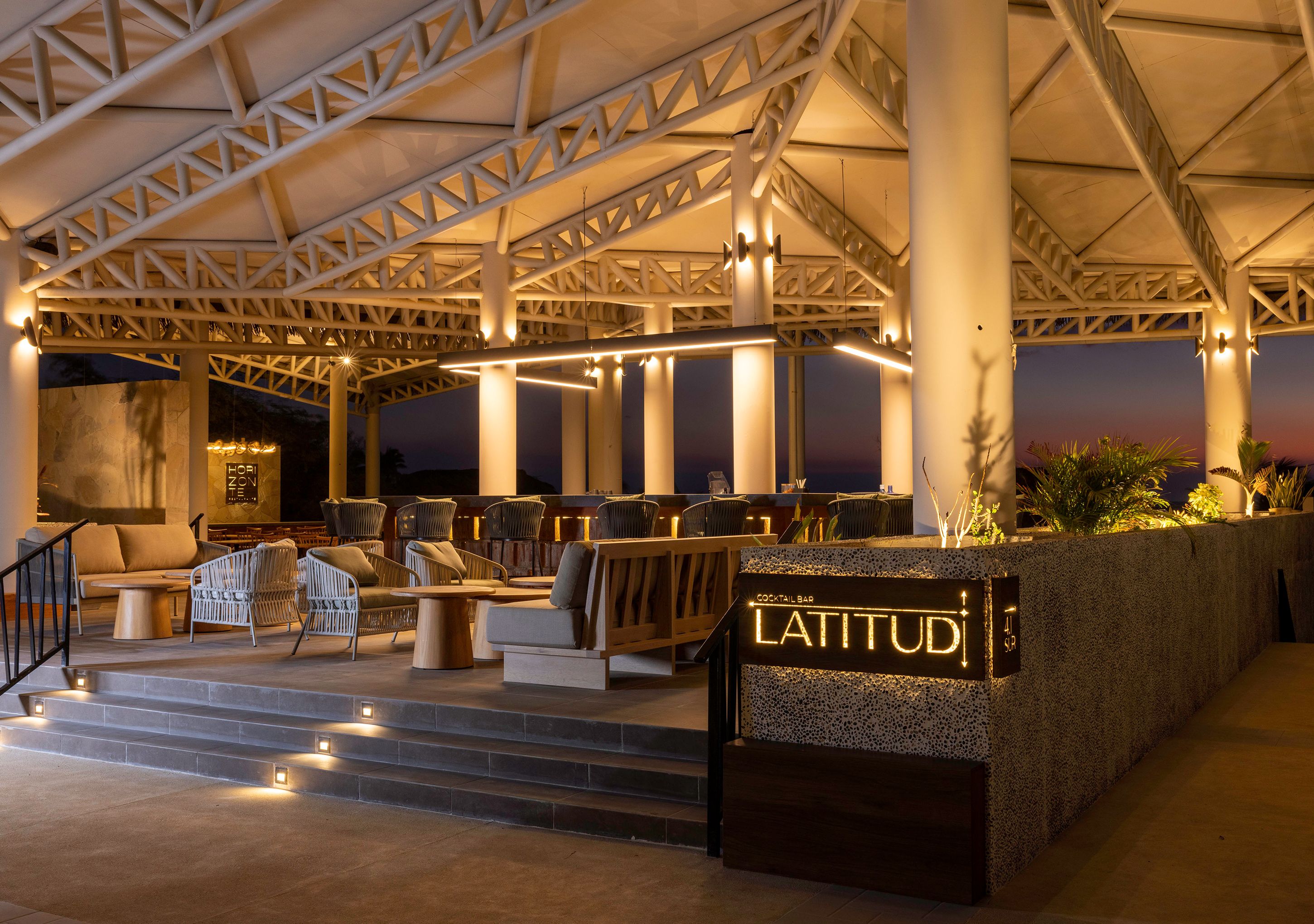 Een cocktailbar genaamd LATITUDI met terras en een modern architectonisch ontwerp.