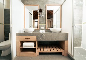 A modern bathroom with a double sink vanity, wooden shelves, and a shower area. - Aranwa Vichayito Beach Resort (Los Organos)