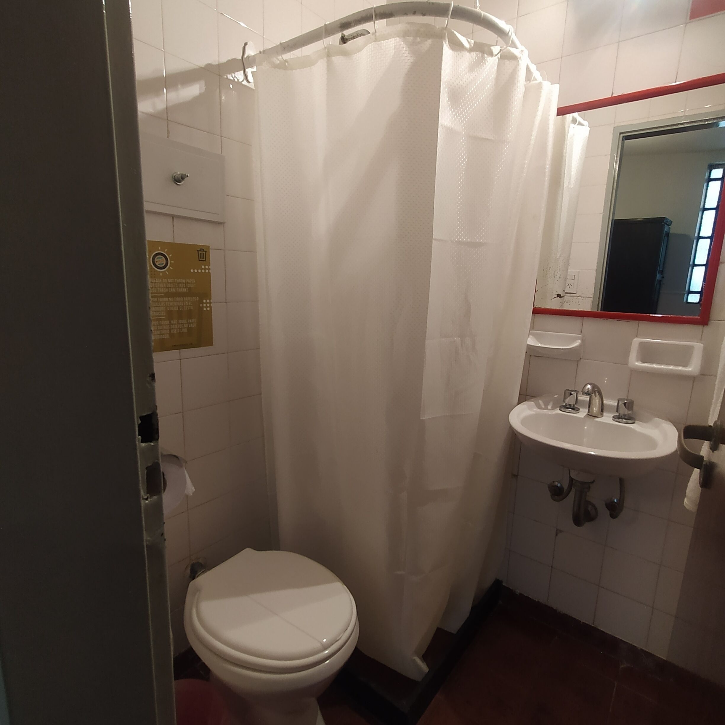 A small bathroom with a toilet, a sink, and a shower curtain.