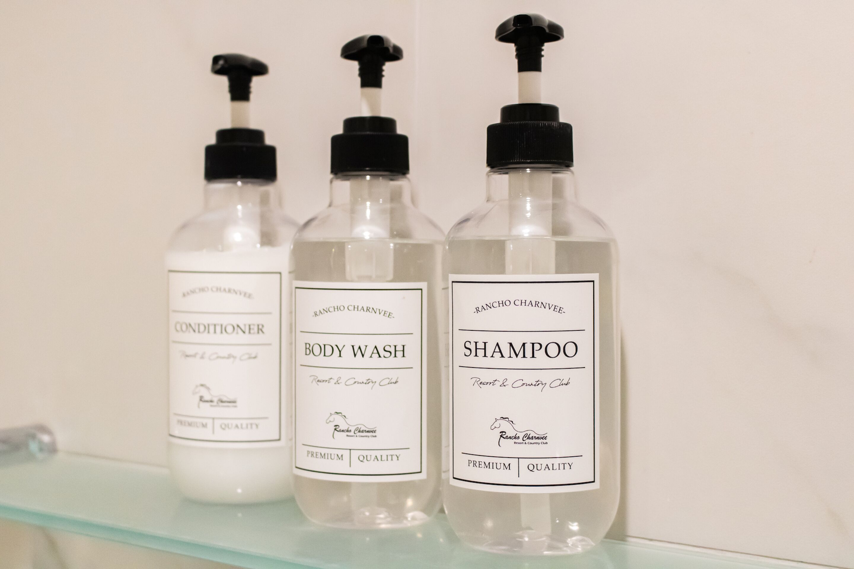 Drei Flaschen Rancho Carnvée Duschgel, Conditioner und Shampoo auf einem Glastablett.