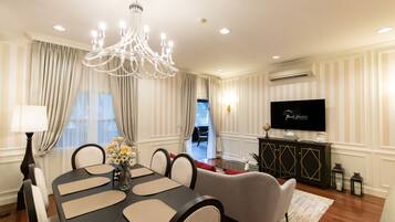 A dining area with a chandelier, a TV, and a view of the outdoors.