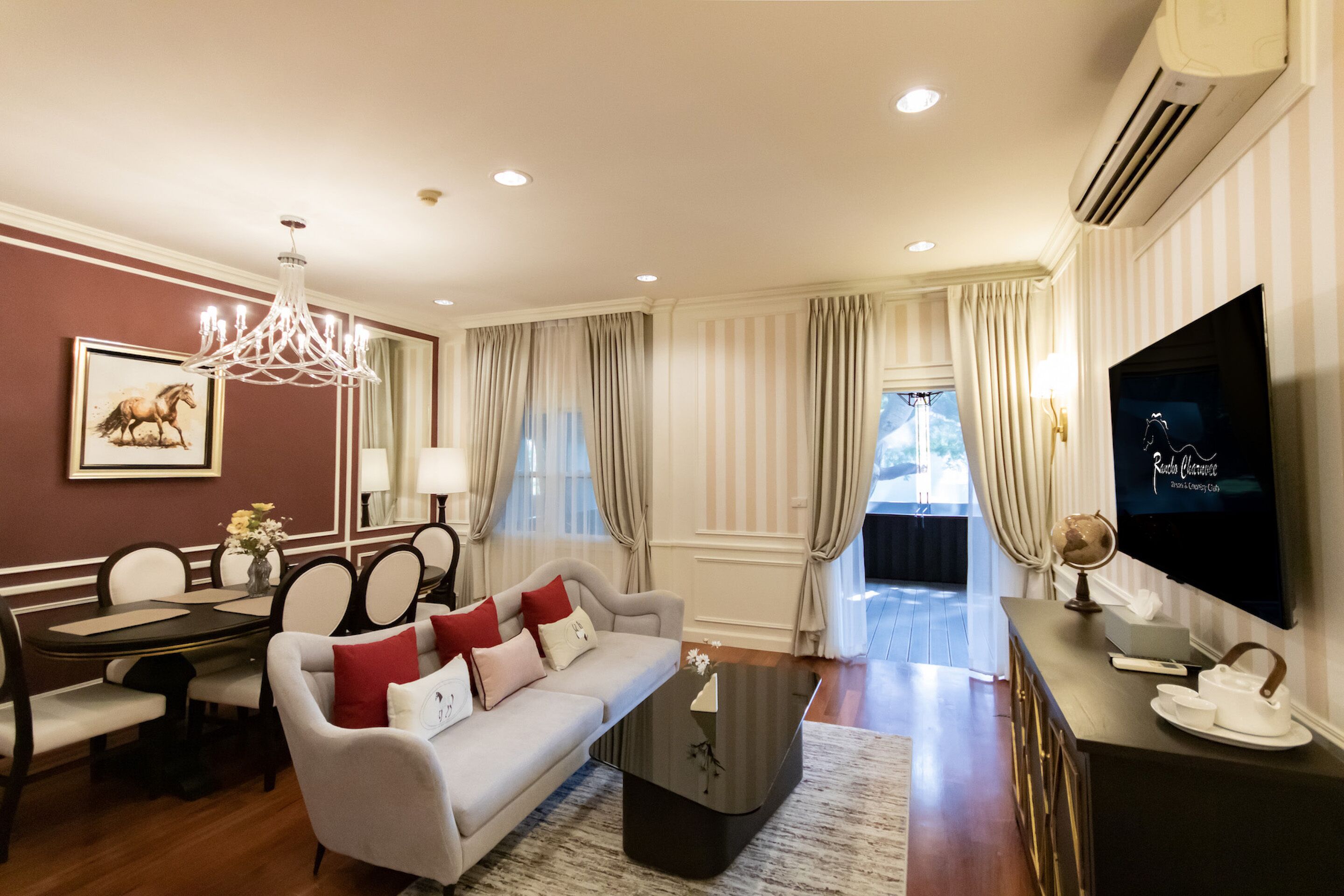 A modern living room with a sofa, dining table, and a flat-screen TV.