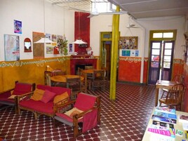 Quarto com piso estampado, móveis de madeira e uma mesa com revistas.