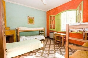 A room with bunk beds, a desk, and a window with shutters. - Casa Pueblo Hostel (Mendoza)