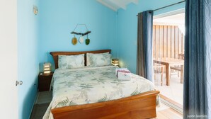 Un dormitorio con cama, lámparas de noche, mesita de noche y vistas a un espacio exterior.