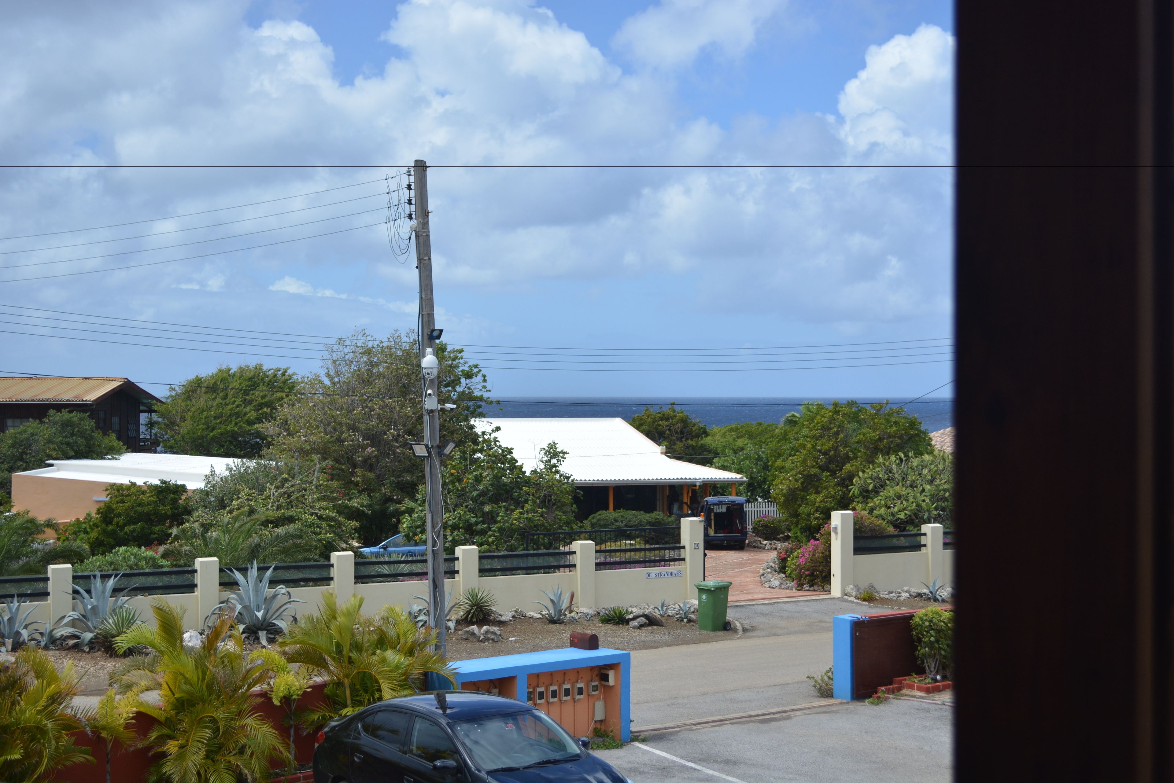 Une vue sur la côte, avec un bâtiment, une voiture garée et un autobus.