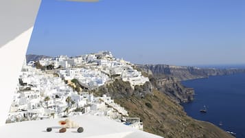 A coastal town with white buildings, a cliffside, and the sea.