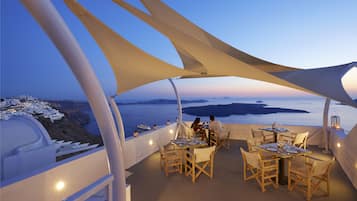 Enjoy al fresco dining with a view of the sea and coastline from this outdoor dining area.