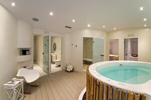 Un baño moderno con bañera, zona de ducha y inodoro.