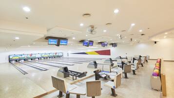 A bowling alley with multiple lanes, seating areas, and digital scoreboards.