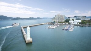 A marina with boats docked, a large building, and a bridge. - Kumho Tongyeong Marina Resort (Tongyeong)