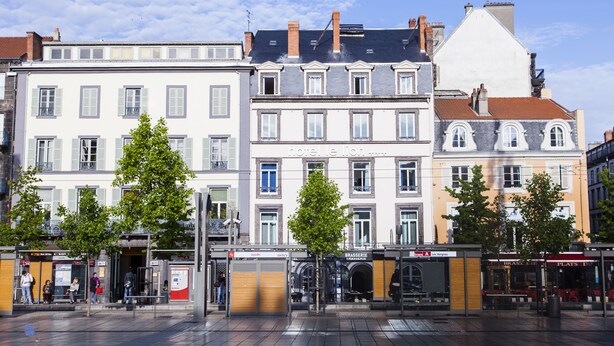 Uma fileira de edifícios em estilo europeu, com um edifício central identificado como 