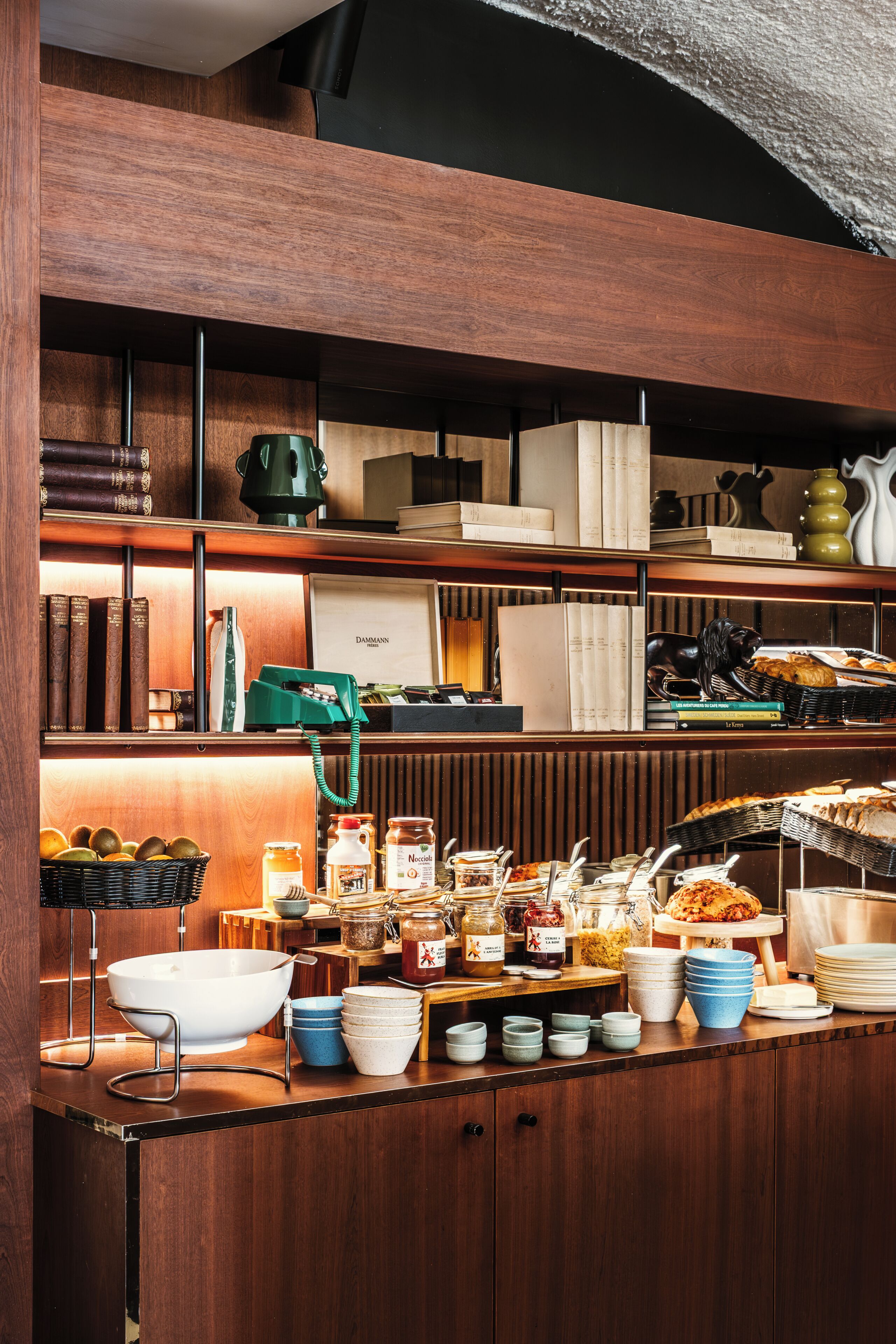 A kitchen counter with various food items, kitchenware, and books.