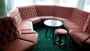 Un coin salon avec un canapé capitonné et une petite table ronde.