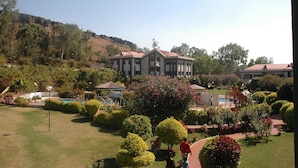 A large building with a central courtyard, surrounded by well-maintained gardens and a pool. - Blue Country Resort (Mahabaleshwar)