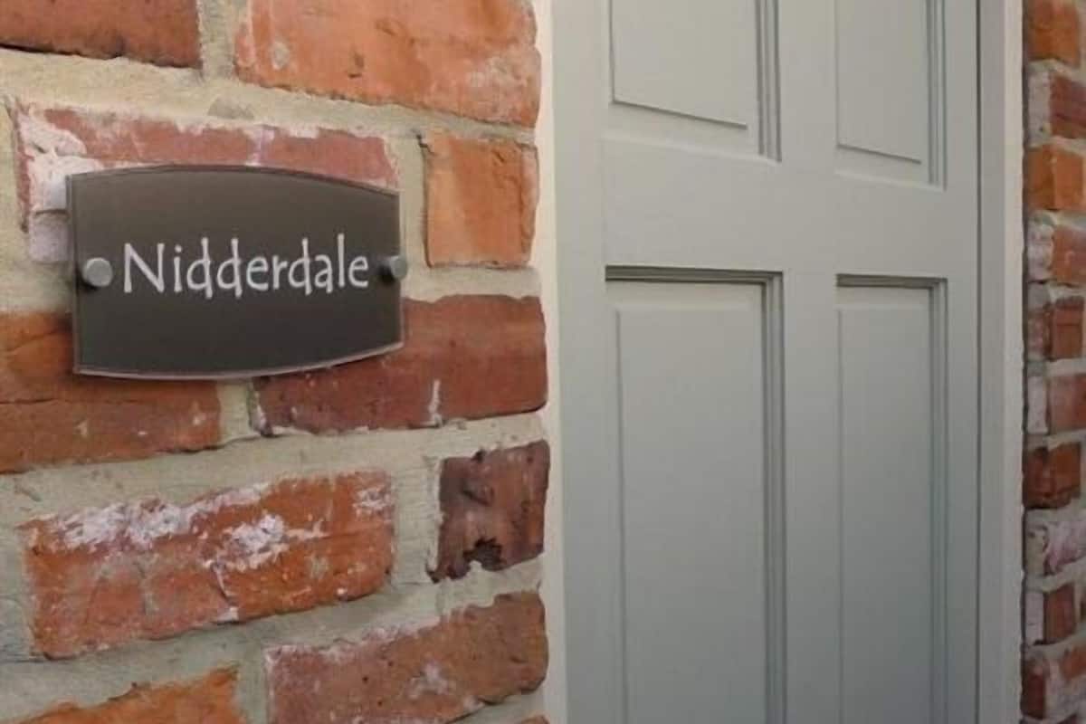 A brick wall with a sign that reads "Nidderdale."