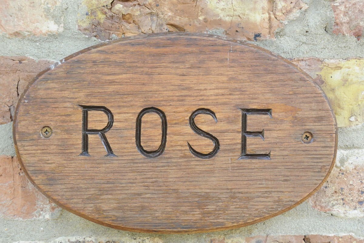 A wooden sign with the word "ROSE" engraved on it.