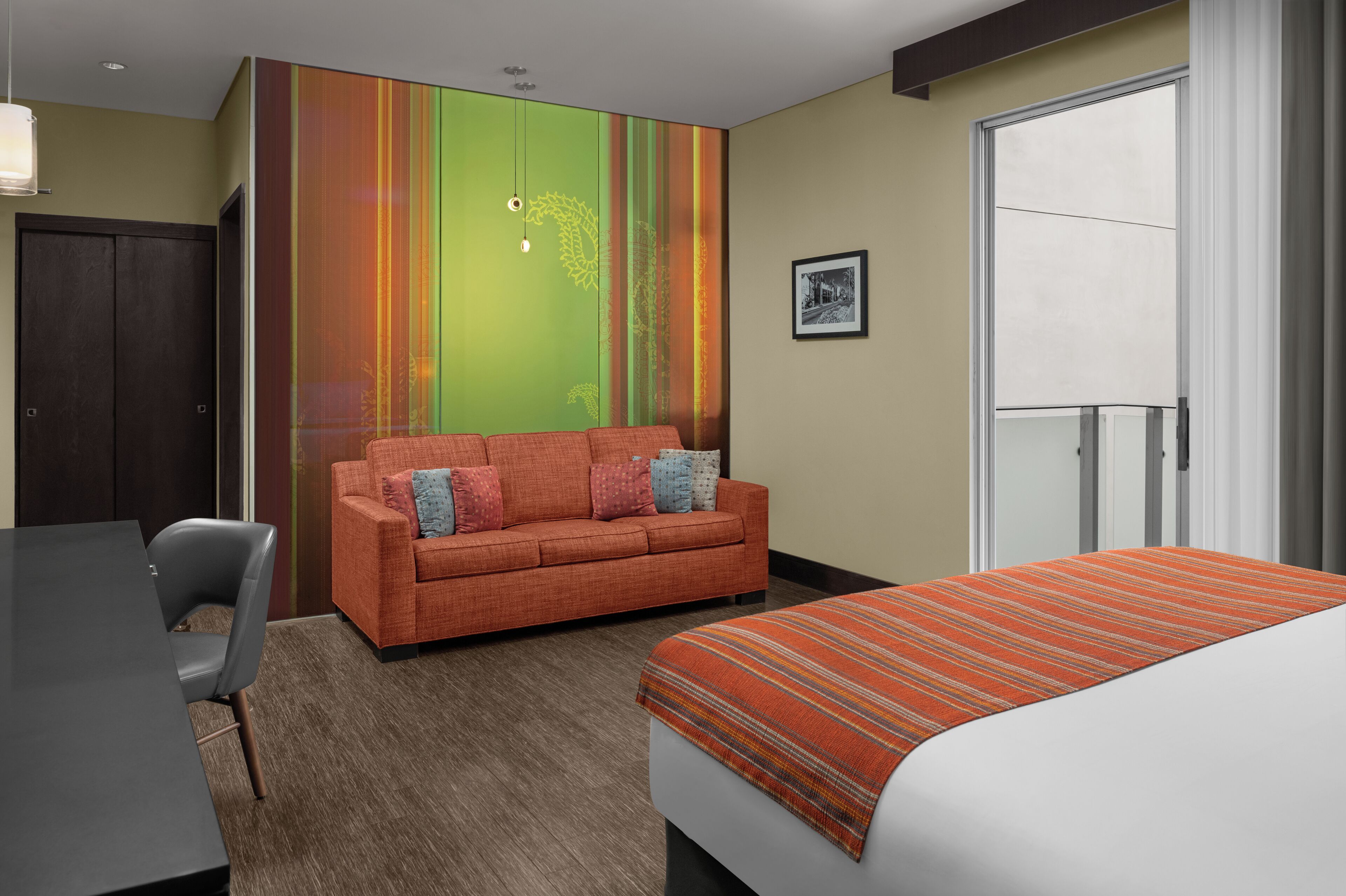 A hotel room with a sofa, a bed, a desk, and a wardrobe.