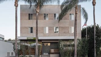 Un edificio moderno con fachada plana, múltiples ventanales y un letrero que dice