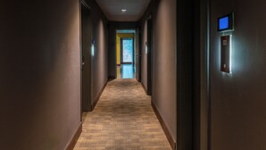 A long, narrow hallway with carpeted floors and walls, leading to a door at the end. - SIRTAJ - Beverly Hills (Beverly Hills)