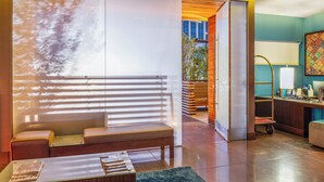 A modern living room with a sofa, a coffee table, and a view of a cityscape through large windows. - SIRTAJ - Beverly Hills (Beverly Hills)