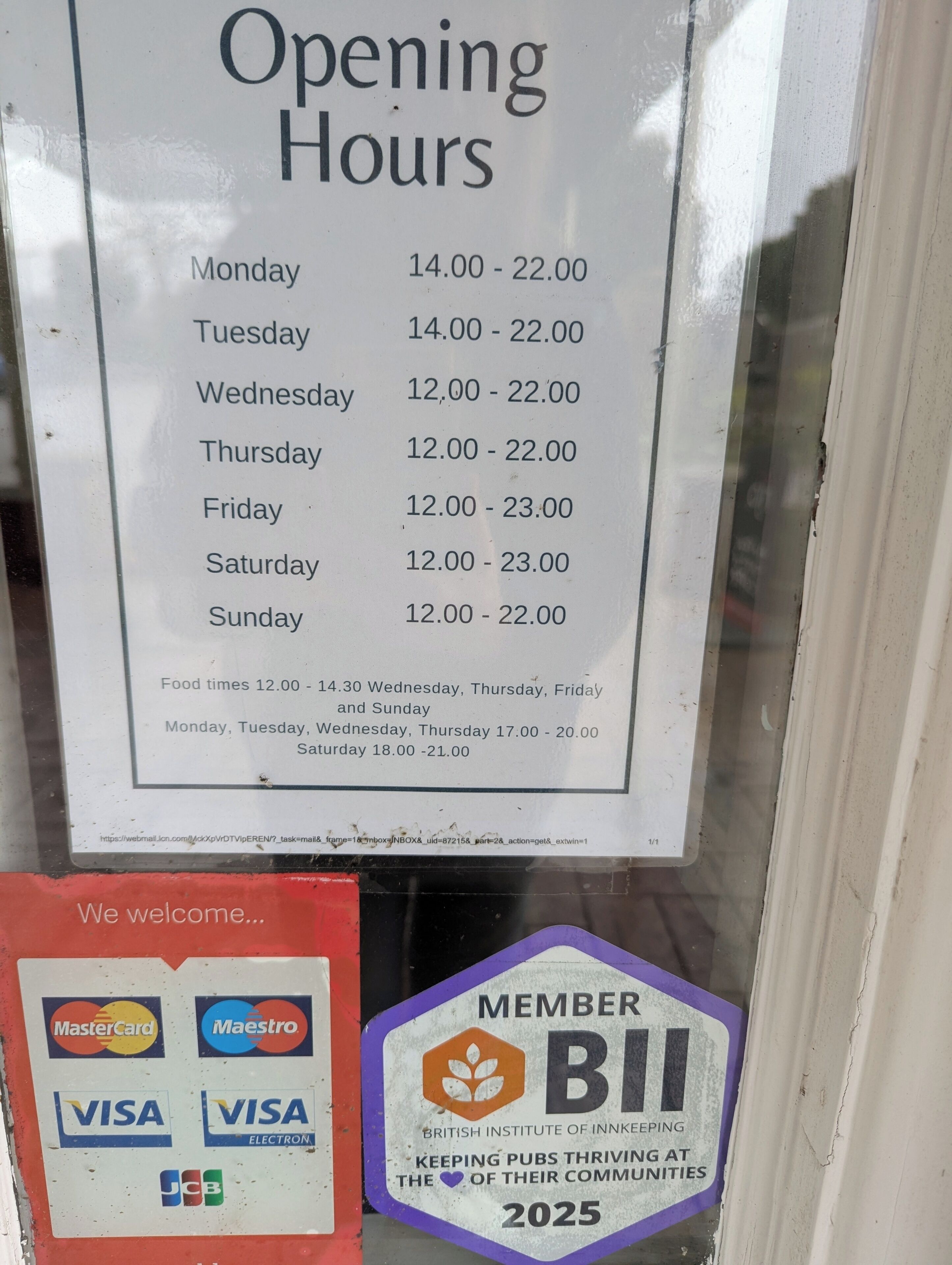 Señal con el horario de apertura de un establecimiento, indicando horarios para días de semana y fines de semana, además de los horarios de comida.