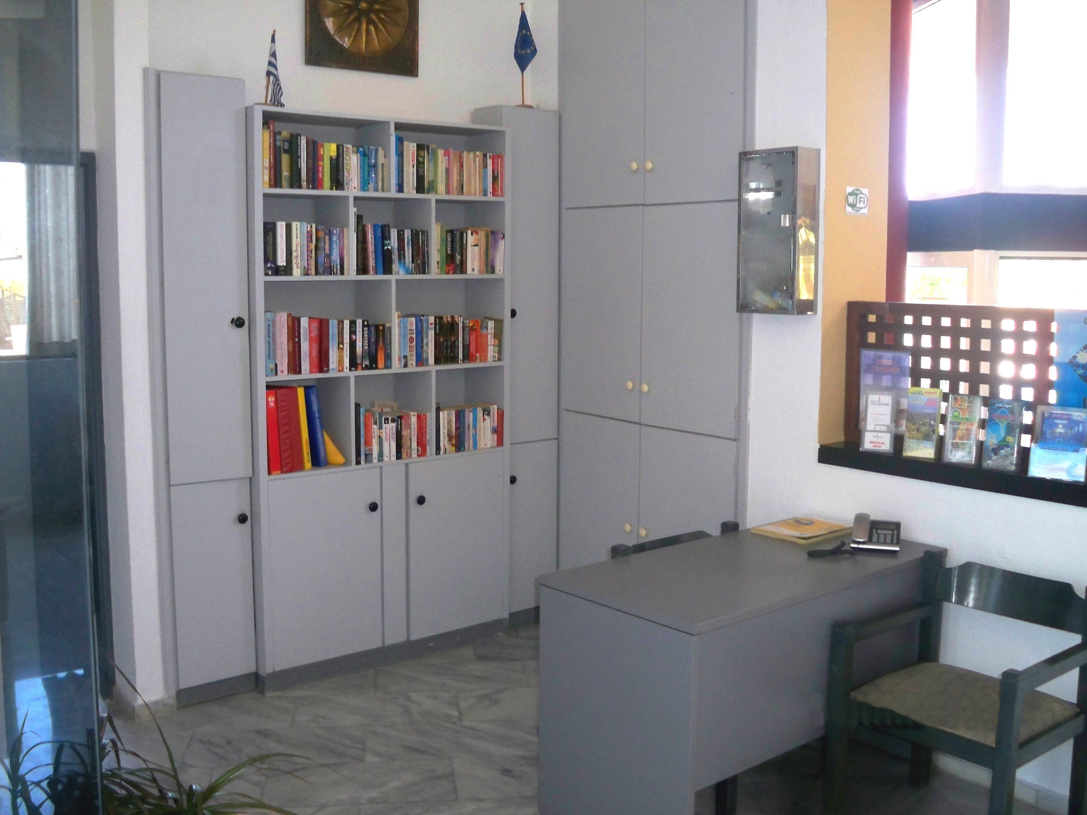 A library with bookshelves, a desk, and a chair.