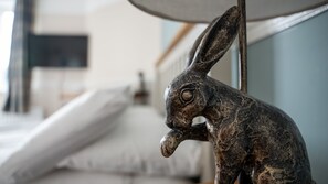 A statue of a rabbit on a table in a room with a bed and a television in the background. - The Star Inn (Lingfield)