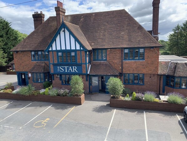 A traditional Tudor-style building with a sign reading "The Star." It features a brick facade, white timber framing, and multiple windows.