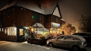 A building with a sign reading "The Star" at night, featuring a traditional design with a pitched roof and visible windows. - The Star Inn (Lingfield)