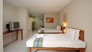 Een hotelkamer met twee bedden, een televisie op een nachtkastje en een schilderij aan de muur.