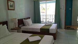 Een hotelkamer met twee bedden, een nachtkastje met een lamp, een lijst met een afbeelding aan de muur, en een balkon met stoelen.