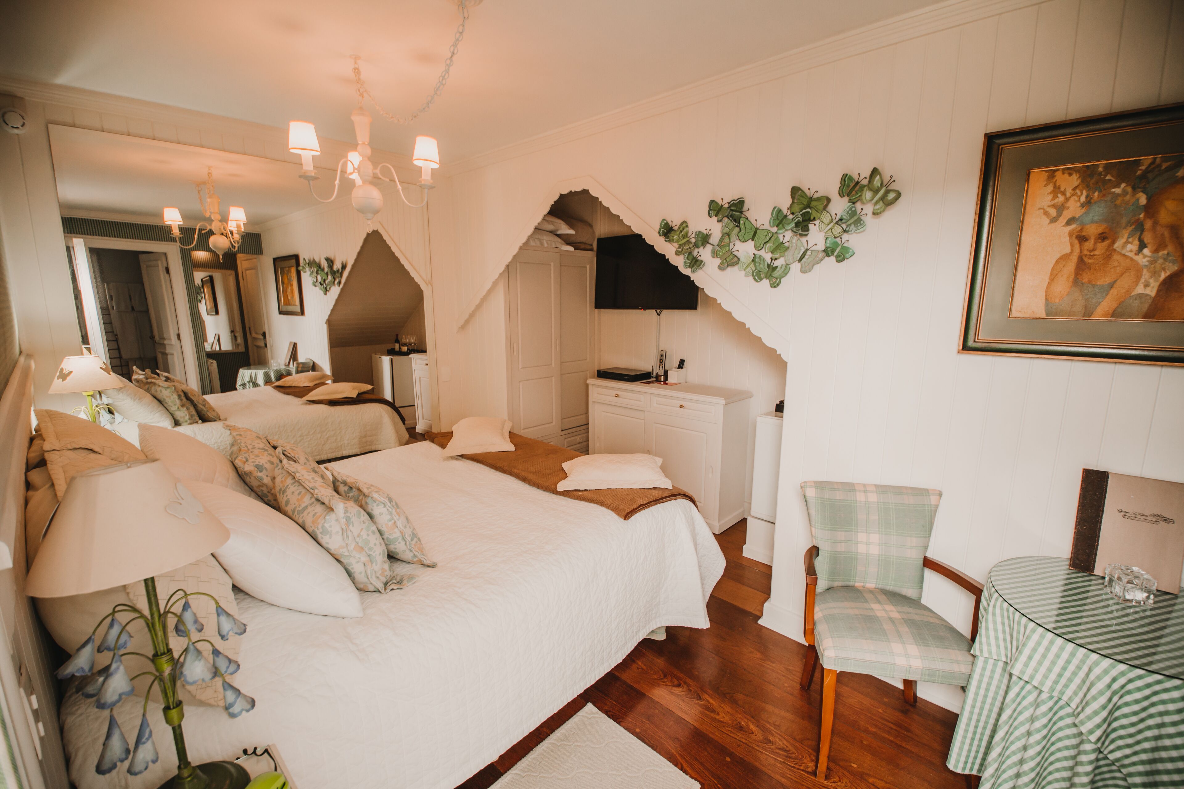 Un dormitorio con una cama grande, una silla, una mesa y un aparador.