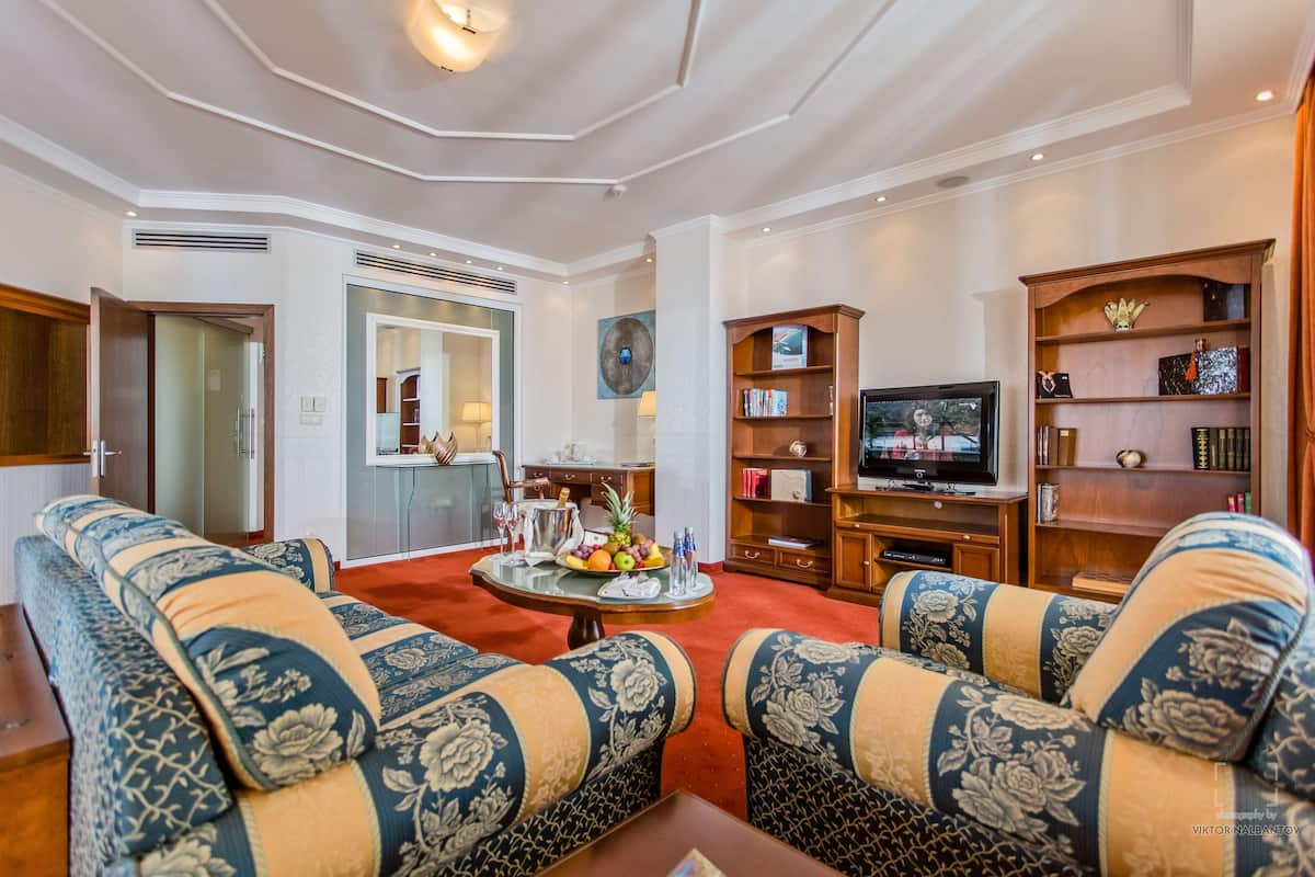 Una sala de estar con un conjunto de sofá, televisión y estantería.