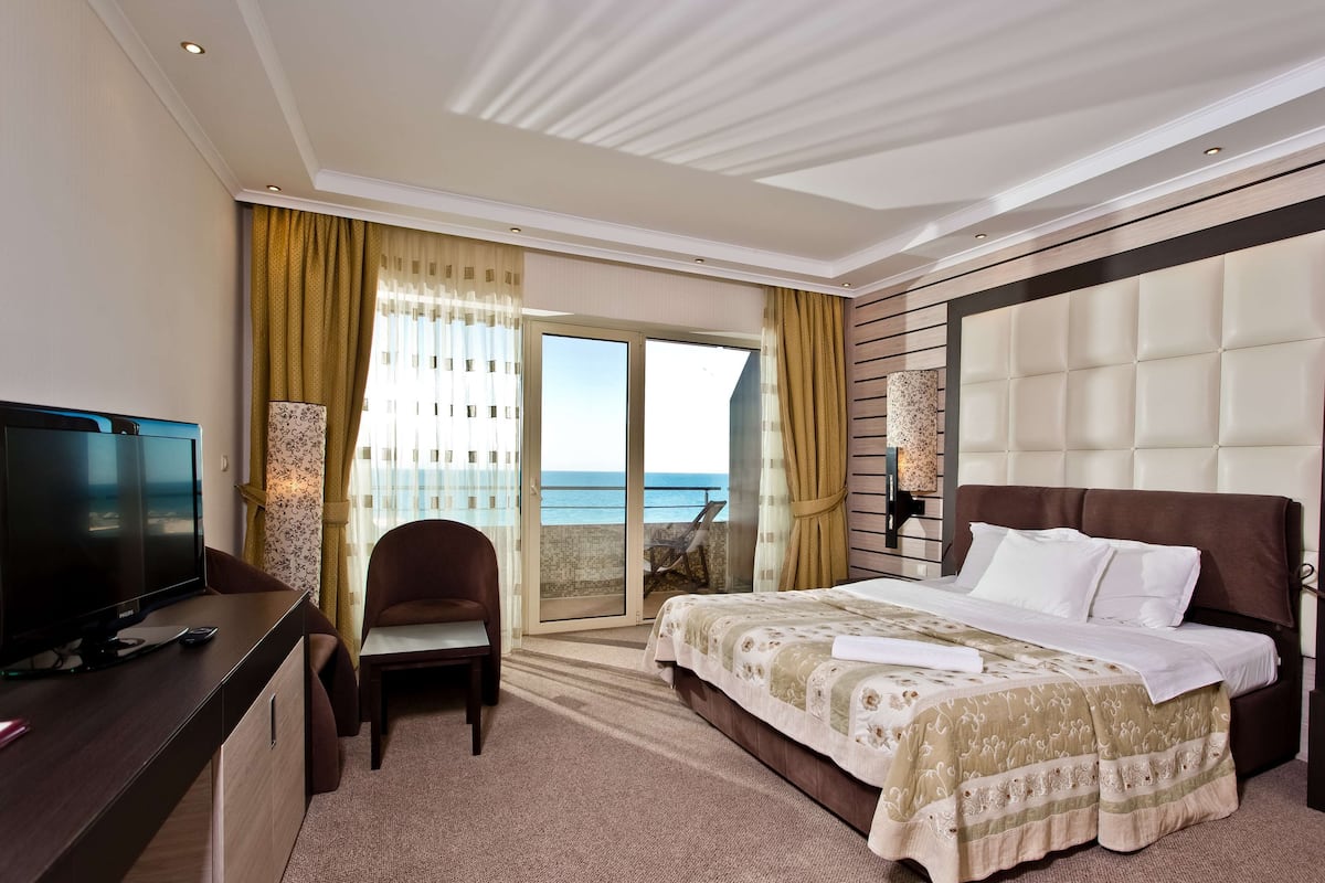 Una habitación de hotel con cama, televisión, escritorio y silla.