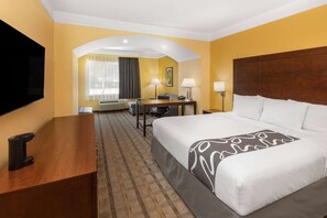 Une chambre d’hôtel équipée d’un lit, d’un bureau, d’une chaise et d’une télévision.