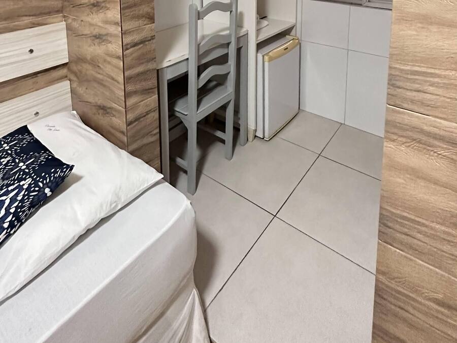 Un dormitorio pequeño con cama, escritorio, silla y armario.