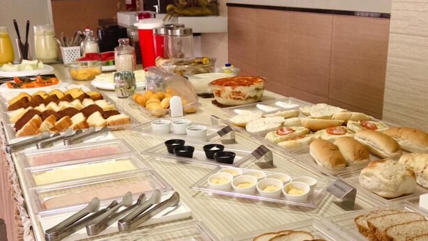 A buffet with various food items including meats, cheeses, and breads. - Pousada São Luis (Aracaju)