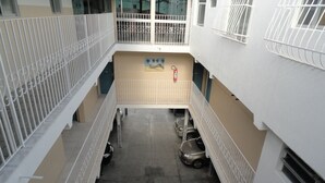 A multi-level parking area with cars parked on the ground floor. - Pousada São Luis (Aracaju)