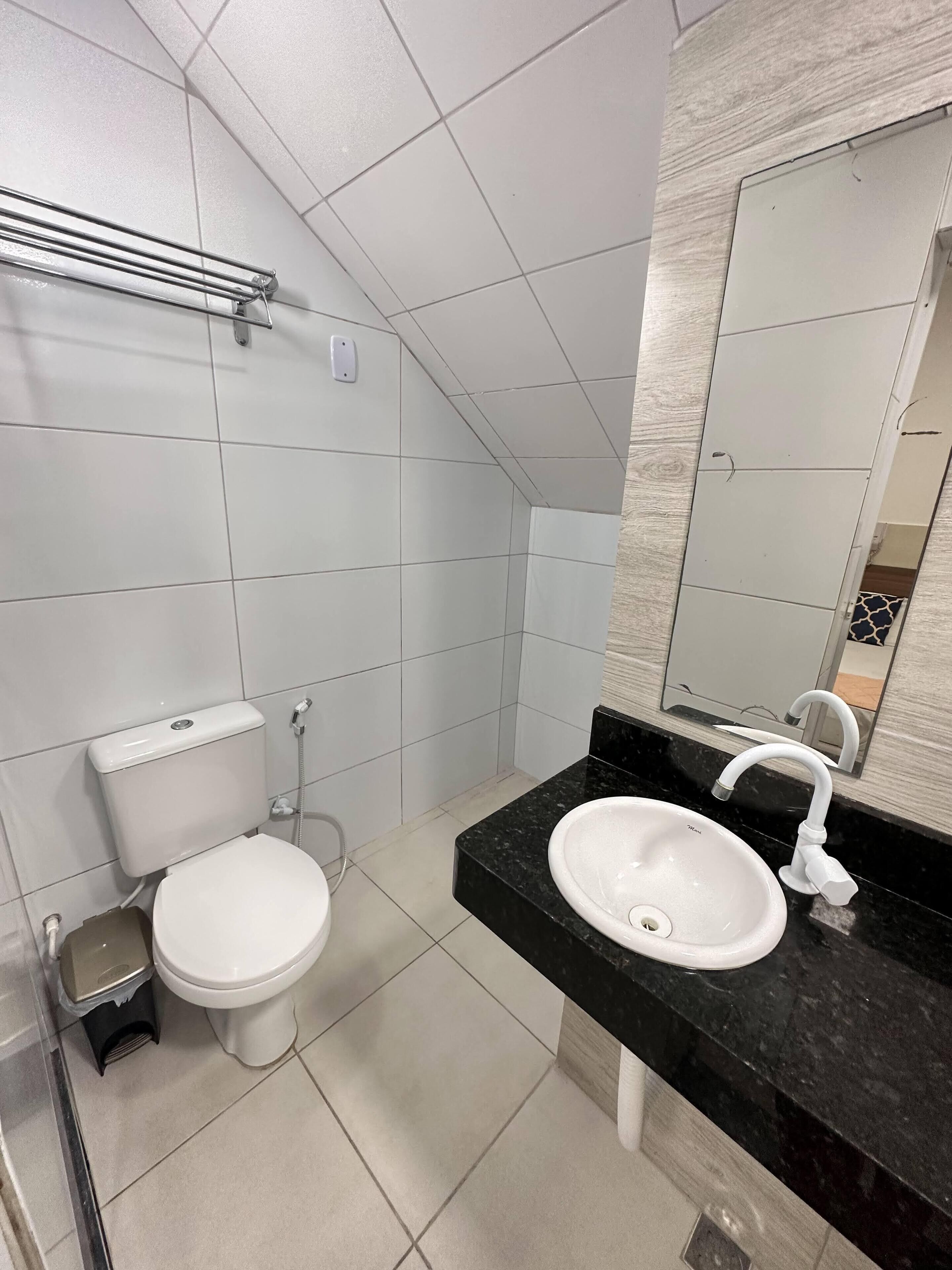 A modern bathroom with a toilet, bidet, and sink.