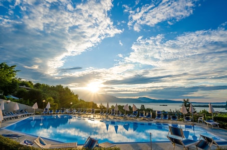 Una piscina al aire libre, sombrillas, sillones reclinables de piscina. Hotel Belvedere