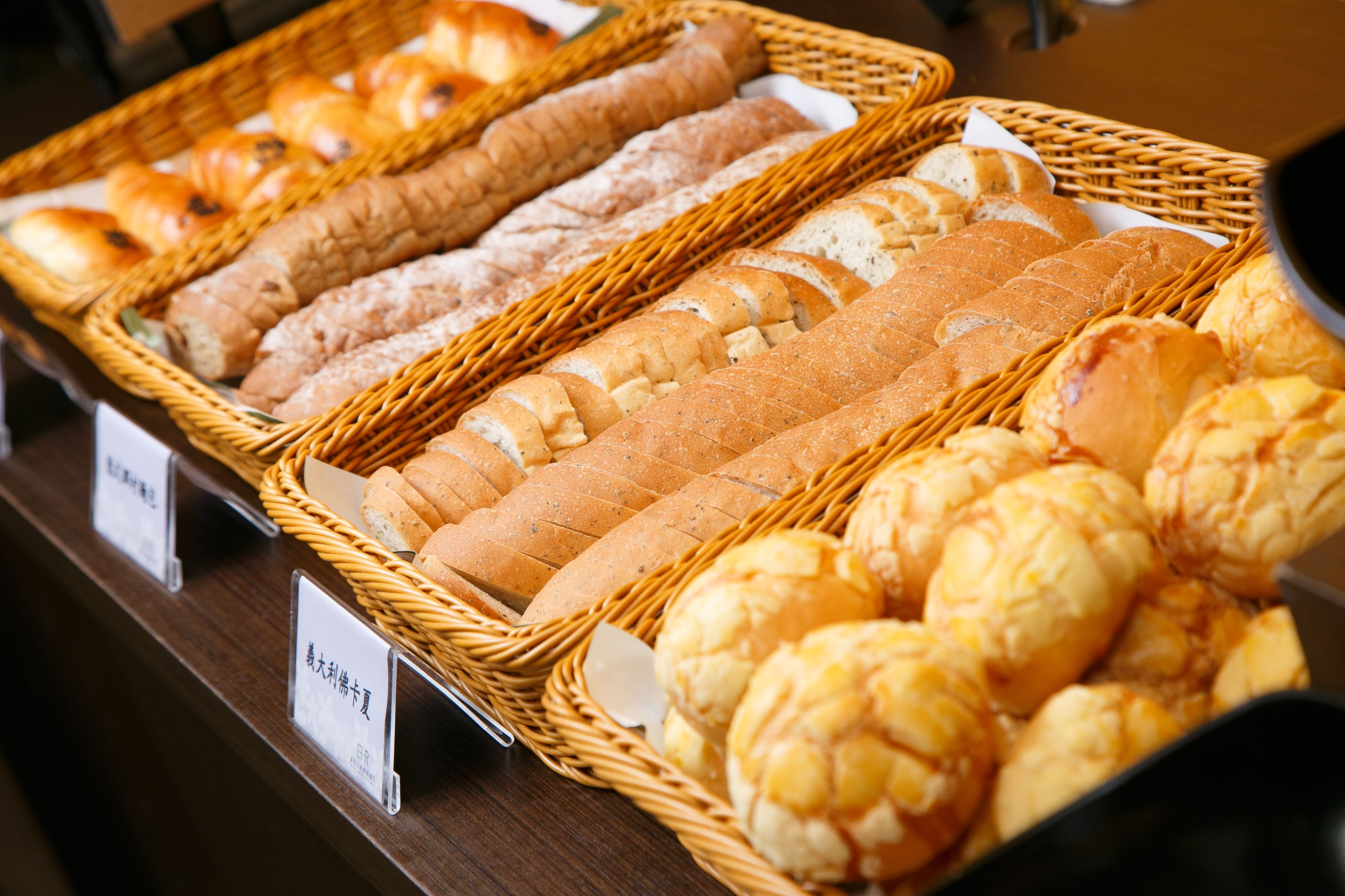 Eine Auswahl an Brot und Gebäck in Korbflechtenkörben.