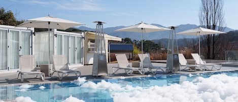 Una piscina al aire libre, cabañas de piscina (de pago), sombrillas