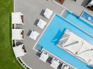 An aerial view of a swimming pool area with multiple white umbrellas and lounge chairs arranged around the pool. - The Suites Hotel Namwon (Namwon)