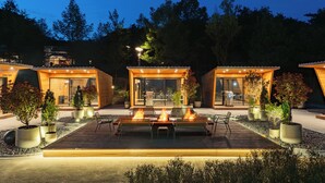 A modern outdoor dining area with a wooden deck, surrounded by potted plants and a wooden fence. - The Suites Hotel Namwon (Namwon)